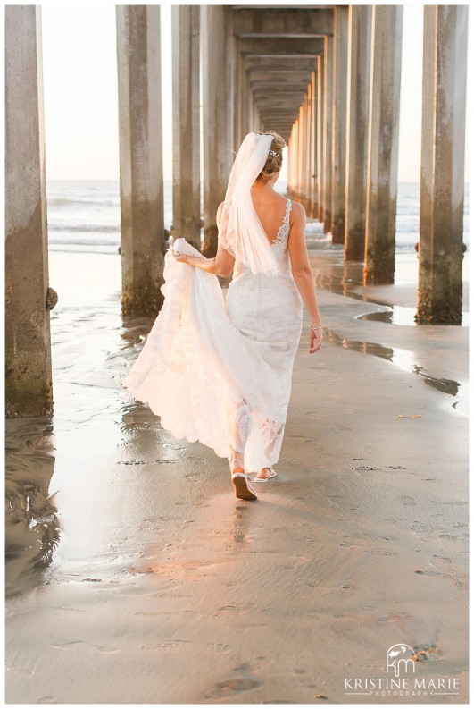 bride walking under pier fine art photographer | Scripps Seaside Forum Wedding | La Jolla San Diego Wedding Photographer | Kristine Marie Photography | © www.kristinemariephotography.com
